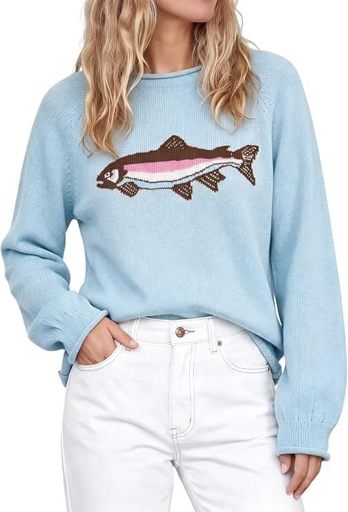 A fashion model wearing the pastel blue aswulk Women Cute Animal Graphic Long Sleeve Pullover Sweater with white pants, showcasing a trendy fall casual aesthetics outfit.
