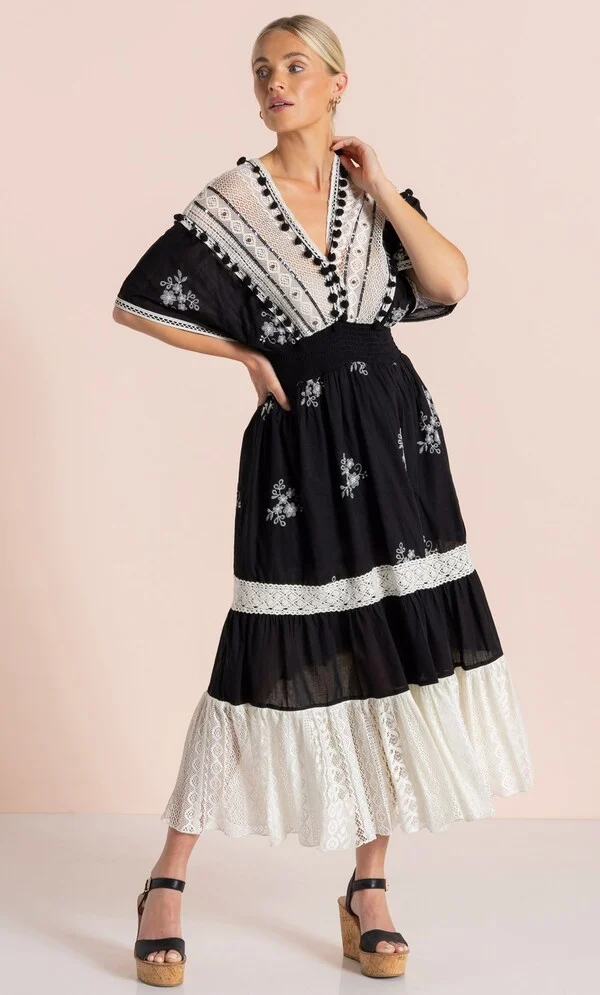15 Stunning Trendy Summer Dresses Ideas To Elevate Your Style In 2026 4 A model showcasing the Embroidery And Lace Cotton Maxi Dress in black and ecru with intricate lace trims and short sleeves, styled for a sunny day out. trendy summer dresses 2026