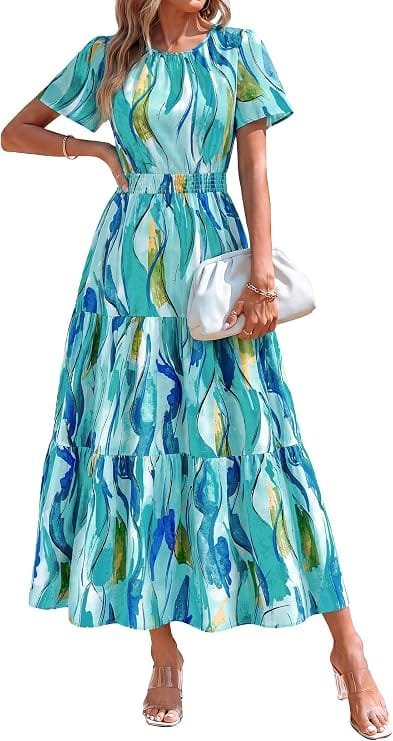 Best Summer Dresses 2026 You Need in Your Wardrobe 10 A model wearing the PRETTYGARDEN Women's Casual Smocked Boho Floral A-Line Maxi Dress 2026 in blue and green floral, featuring short flutter sleeves and a tiered skirt for warm-weather fashion. summer dresses 2026