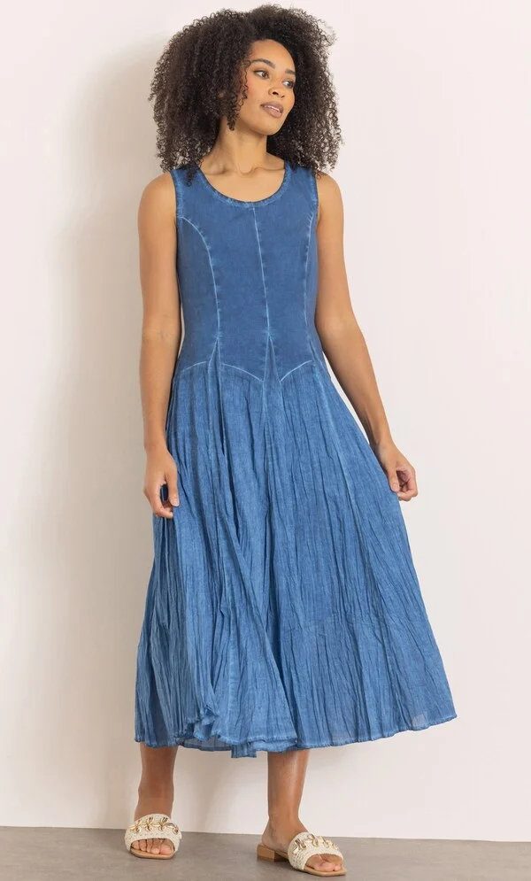 15 Stunning Trendy Summer Dresses Ideas To Elevate Your Style In 2026 13 A model wearing the Sleeveless Cotton Blend Parachute Dress in denim blue featuring a round neckline and a washed effect panelled skirt, styled for casual warm-weather wear.