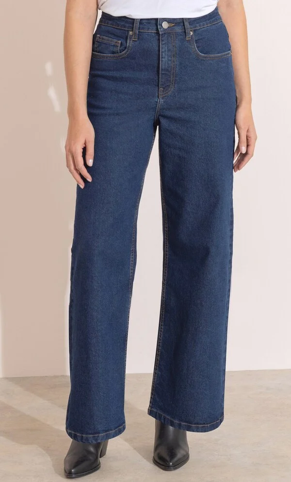 The Perfect Office Capsule Wardrobe: 2026 Work Essentials Guide 10 Full-length shot of a professional woman wearing blue wide-leg stretch jeans paired with a chic knit top, styled for an office capsule wardrobe aesthetic.