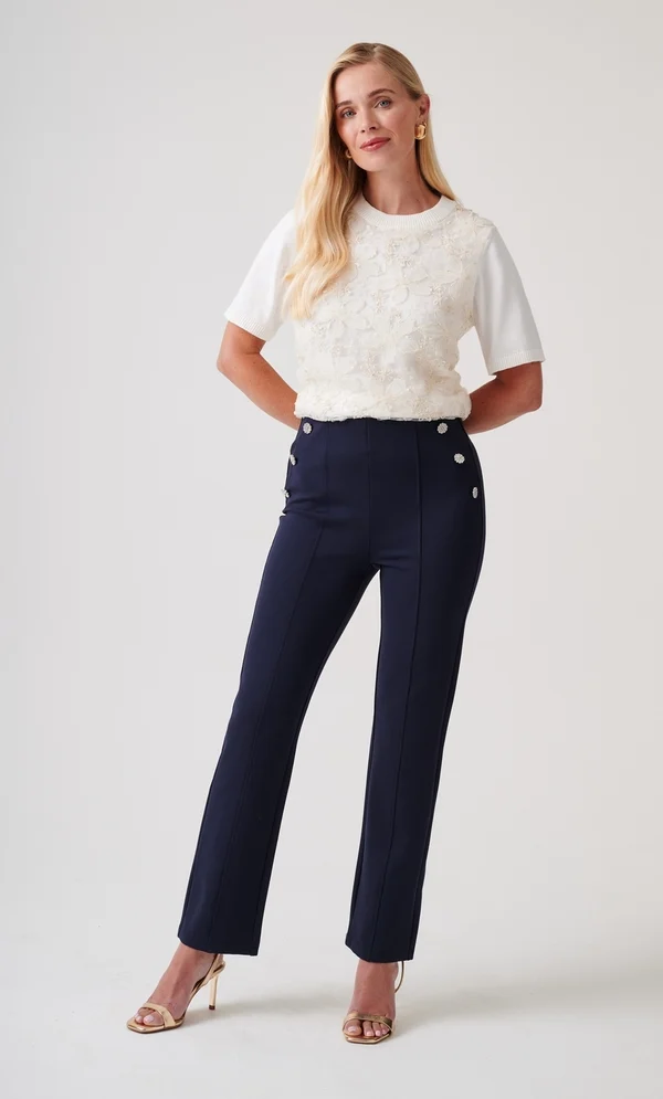 The Perfect Office Capsule Wardrobe: 2026 Work Essentials Guide 15 Full-length studio shot of a model wearing Klass midnight blue embellished straight-leg pull-on trousers with decorative side buttons and front pintucks, styled for an office workwear capsule.