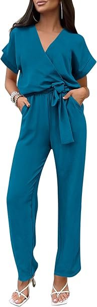 Full-length studio photography of a model wearing the PRETTYGARDEN Women's One Piece Jumpsuit in a vibrant lake blue shade, featuring a wrap V-neck top, a tied waist belt, and wide-leg trousers designed for cocktail parties and summer weddings.