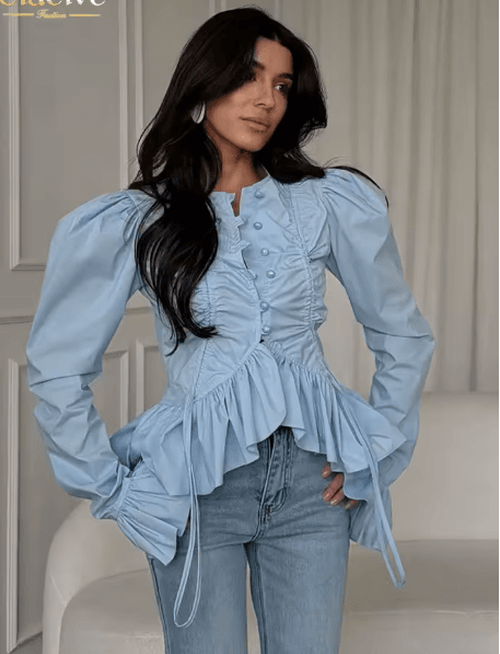 25 Minimalist Capsule Wardrobe Essentials 2026 | Timeless Pieces Every Woman Needs 10 A model wearing an elegant slim-fit light blue cotton blouse with classic ruffle details, styled in a professional yet feminine outfit, perfect for 2026 fashion trends. This piece is a must-have among your minimalist capsule wardrobe essentials for 2026.