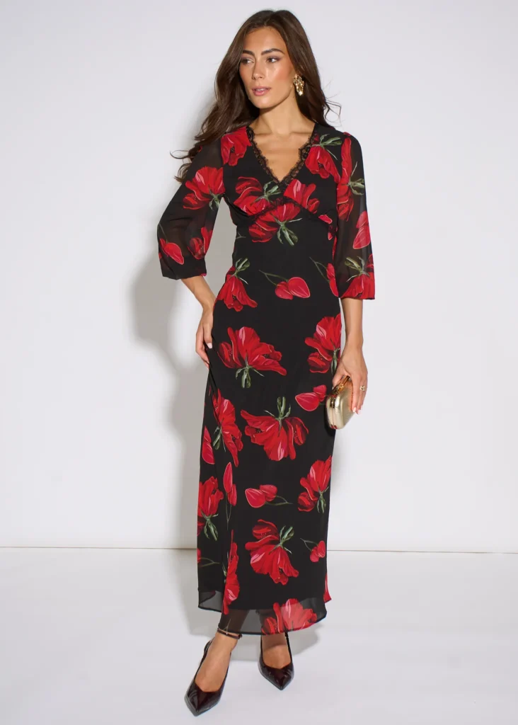 Trendy & Affordable Outfits for Women You'll Actually Love (2026) 12 A stylish woman wearing an affordable black midi dress featuring a vibrant red floral print and lace trim detailing, styled for a chic evening out featuring Trendy Outfits for Women.