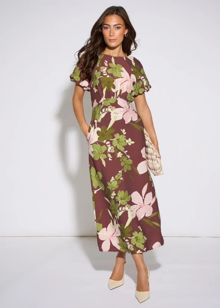 Trendy & Affordable Outfits for Women You'll Actually Love (2026) 11 A stylish woman wearing an affordable brown floral puff sleeve midi dress with pink and green accents, styled for a chic daytime event featuring Trendy Outfits for Women.