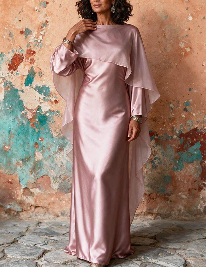Trendy & Affordable Outfits for Women You'll Actually Love (2026) 9 A stylish woman wearing an affordable pink satin long-sleeve modest dress with a dramatic cape overlay and tie-back belt, styled for an elegant evening event featuring Trendy Outfits for Women.